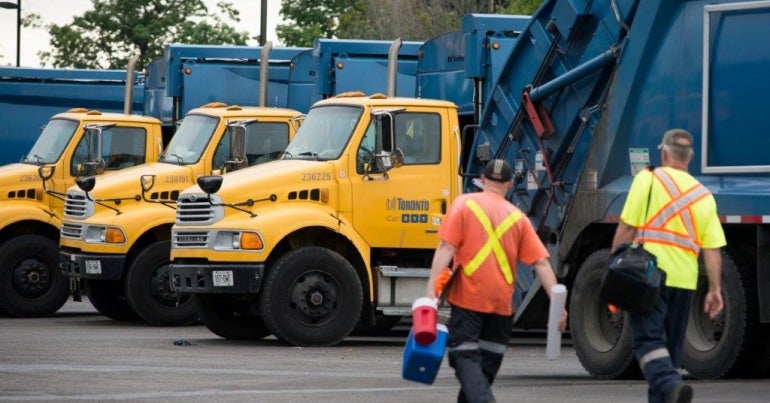Toronto solid waste removal trucks and workers