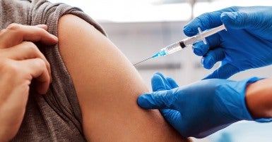 An arm being vaccinated