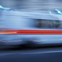 An ambulance travels so fast it is a blur