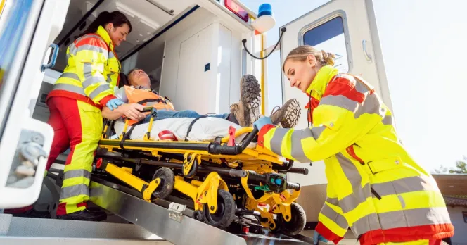 Paramedics load an injured worker on to an ambulance